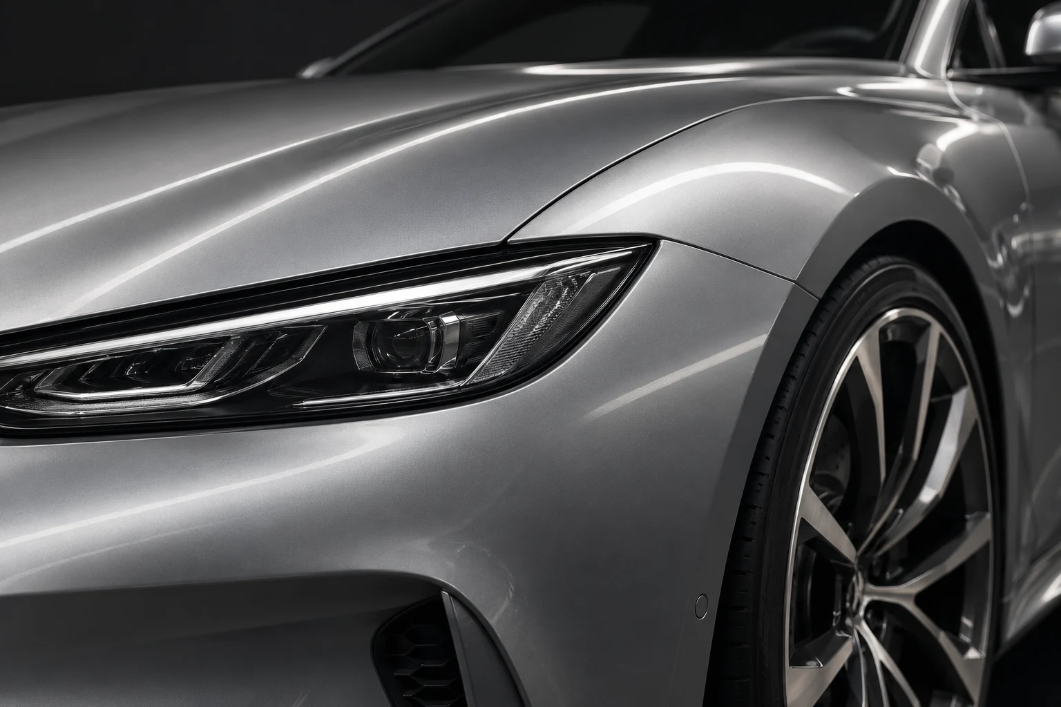 Illustrative close view of silver bodywork and a headlamp